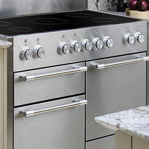 Stainless steel electric range with multiple oven compartments and sleek control knobs.