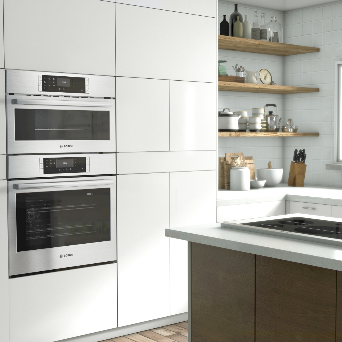 A Bosch stainless steel wall oven and speed oven combination installed in a floor-to-ceiling white cabinetry column, with a black induction cooktop on the island and open wood shelving in the background.